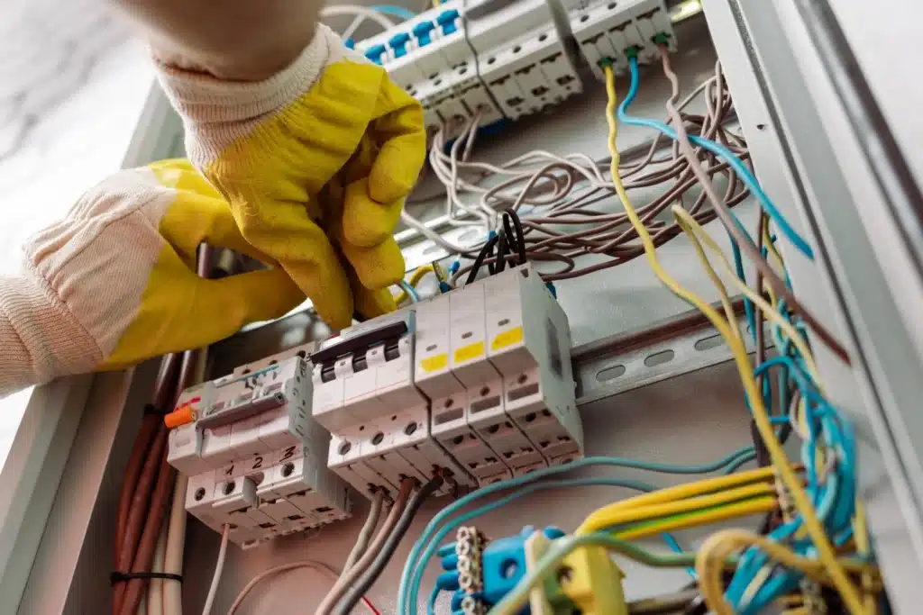 électricien effectuant un dépannage et réglant un tableau électrique